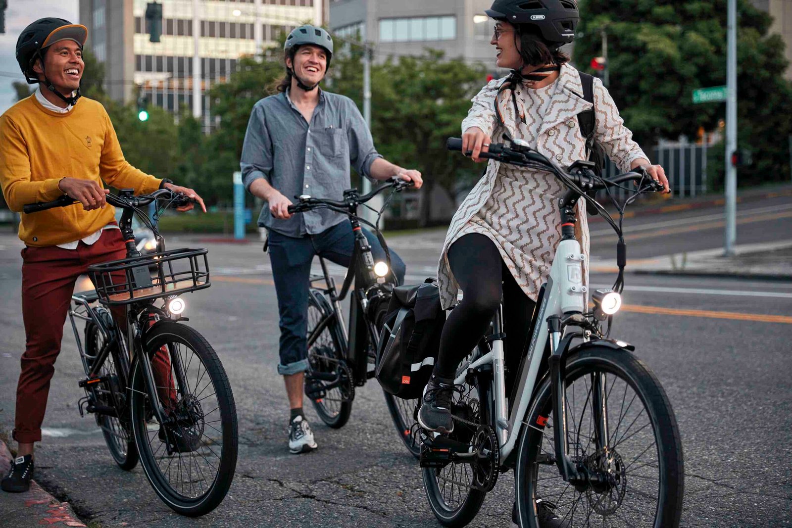 Three friends riding RadCity 5 Plus electric bikes together through a scenic city park