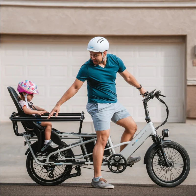 Father riding the Lectric XPedition 2.0 cargo electric bike with his child safely seated on the rear passenger seat