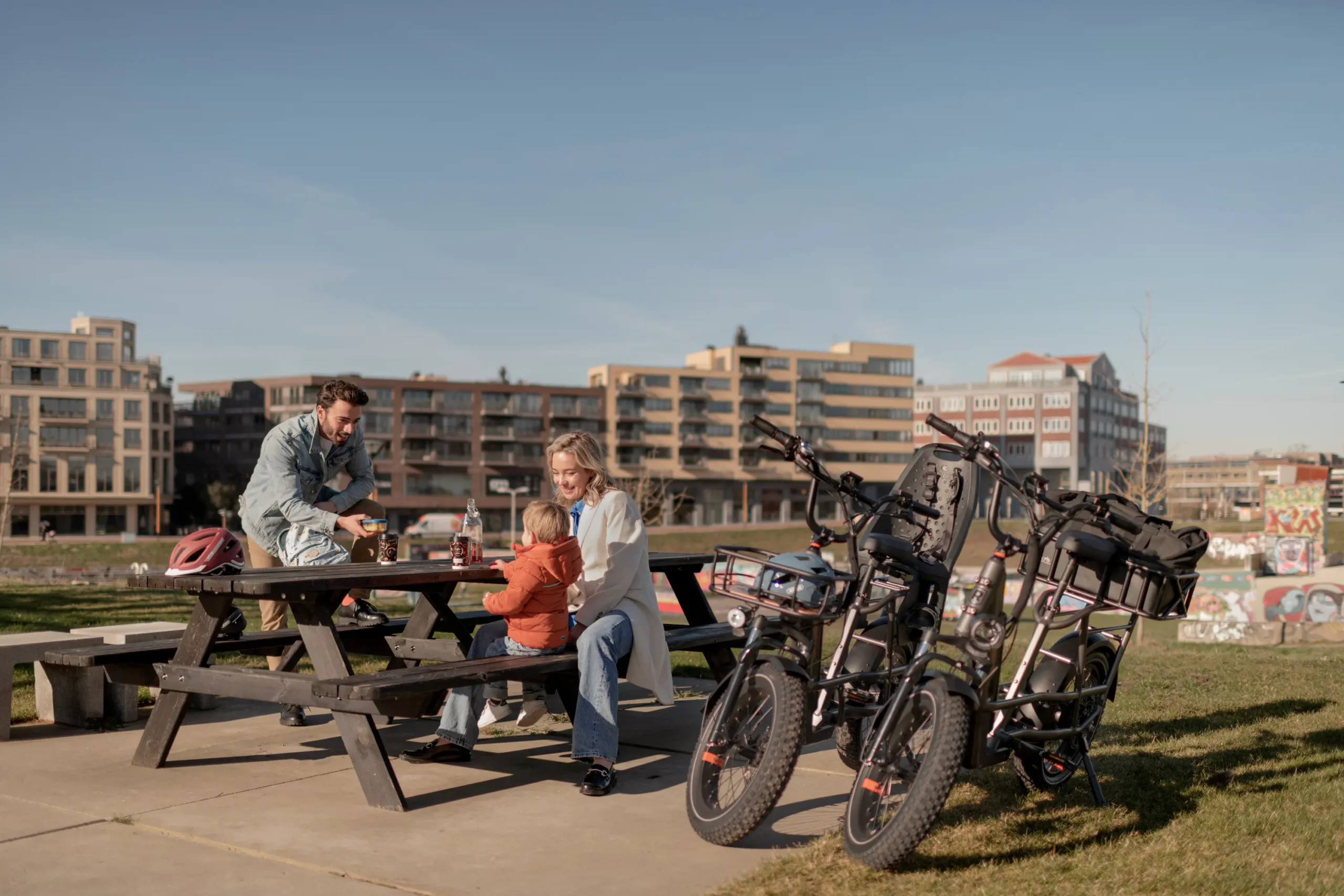 Family enjoying a ride together on RadRunner 3 Plus utility electric bikes through a neighborhood park