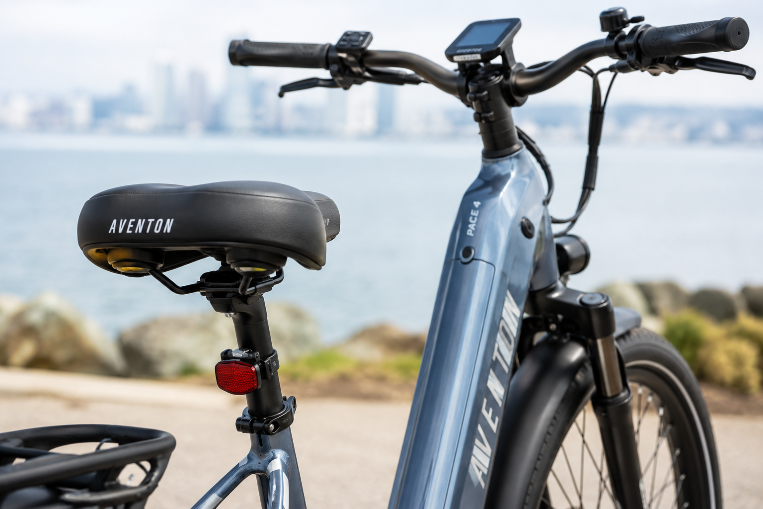 Aventon Pace 4 close-up showing the ergonomic saddle, swept-back handlebars, and step-through frame design.