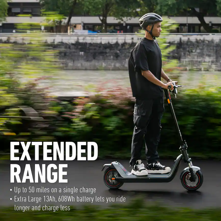 A person riding an electric scooter along a scenic riverside path with motion-blurred greenery in the background.