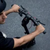 First-person overhead perspective of a rider’s hands gripping the handlebars of a Segway electric scooter, featuring a bright central LED dashboard display.