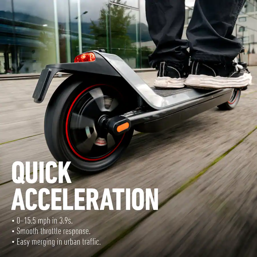 Close-up of a person's feet on a moving electric scooter deck, capturing motion blur on the rear wheel.