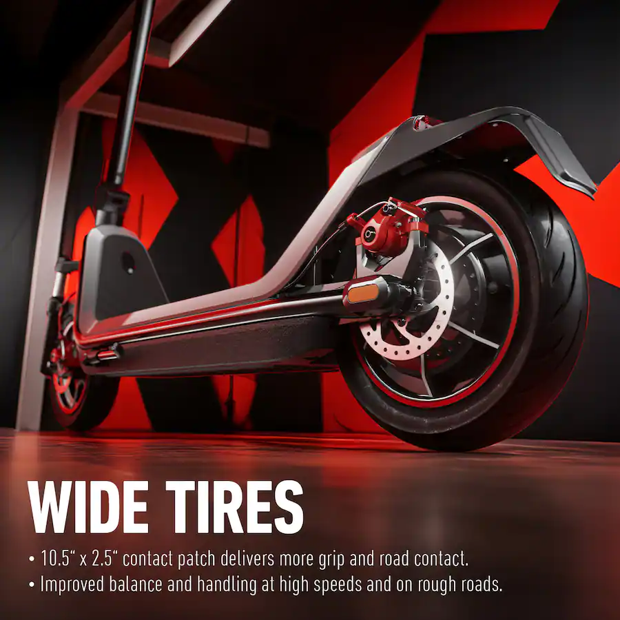 Low-angle close-up of an electric scooter's rear tire and dual disc braking system against a geometric black and red backdrop.