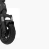 A focused, angled close-up shot of the front wheel and suspension system of the dark gray NIU KQi 200P electric scooter, parked indoors with a plain white background to the side, highlighting the dual hydraulic fork suspension.