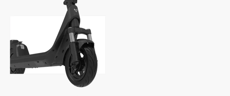 A focused, angled close-up shot of the front wheel and suspension system of the dark gray NIU KQi 200P electric scooter, parked indoors with a plain white background to the side, highlighting the dual hydraulic fork suspension.