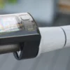 Close-up of the digital handlebar display screen and right rubber grip on an electric scooter.