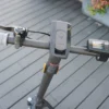Overhead view of black electric scooter handlebars showing the brake lever, mechanical bell, center headlight module, and display.